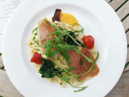 Top view of gourmet pasta dish with parma ham and cheese sauceの写真素材