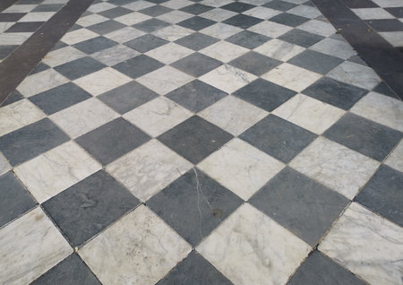 View of black and white geometric tiled chequered marble floorの写真素材