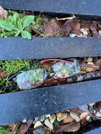 Old discarded spectacles lying on ground in drain gridの写真素材
