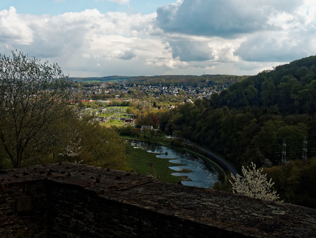 The river Ruhr lies in shadows on a cloudy day. Viewed from the ruins of a medieval castle.の写真素材