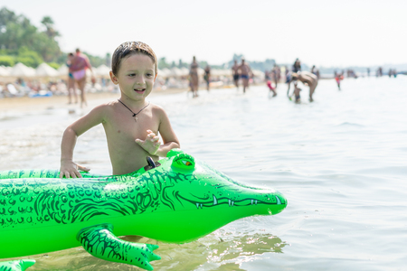 Portrait smiling little baby boy playing in the sea, ocean. Positive human emotions, feelings, joy. Funny cute child making vacations and enjoying summer.の写真素材