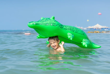 Portrait smiling little baby boy playing in the sea, ocean. Positive human emotions, feelings, joy. Funny cute child making vacations and enjoying summer.の写真素材