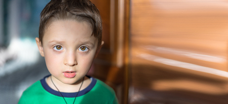 Close up portrait of a surprised european baby boy looking at camera over light backgroundの写真素材