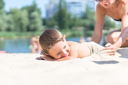 Little baby boy sitting and playing with the sandの写真素材