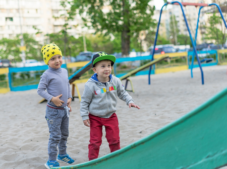 Two little boys friends in sunny day. Brother love. Concept friendship. Portrait of two boys, brothers and best friends smiling. Friends running on the playground.の写真素材