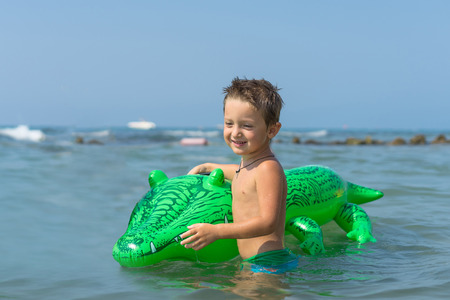 Grandfather, grandmother and grandson playing and splashing in the sea water. Portrait of happy little kid boy on the beach of ocean. Funny cute child making vacations and enjoying summer.の写真素材