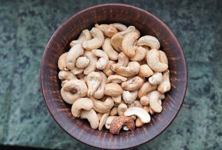Healthy food  for background image close up cashew nuts.  Nuts texture on white grey table top view on the cup plateの写真素材
