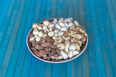 Healthy food. Nuts mix assortment on stone texture top view. Collection of different legumes for...