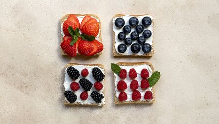 Set of sweet sandwiches with ricotta cheese and fresh forest berries over a marble background. Breakfast. Top viewの写真素材