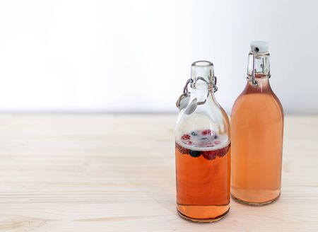 Two glass bottles of fruit kombucha tea. Homemade fermentation, copy space.の写真素材