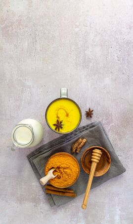 Ayurveda golden turmeric milk with ingredients. Vertical orientation, flat lay, copy space.の写真素材