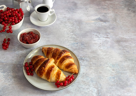 Fresh butter croissants with berries, jam, and coffee. Breakfast concept, copy space.