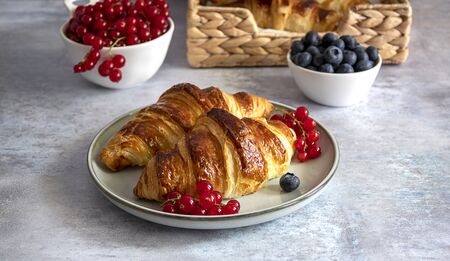 Baked fresh butter croissants with berries, jam, and coffee. French breakfast conceptの写真素材