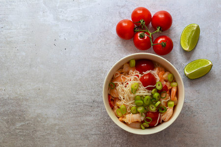 Shirataki Noodles with shrimps, tomatoes, and green onions close-up. Ketogenic, gluten-free diets or...