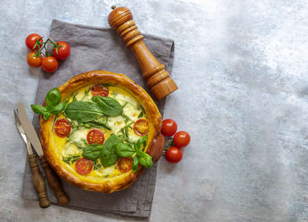 Vegetarian spinach pie or quiche with feta and mozzarella cheese with tomatoes. Copy space for recipe or text.の写真素材
