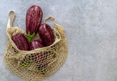 Textile string bag with ripe organic eggplants. No plastic zero waste shopping concept.の写真素材