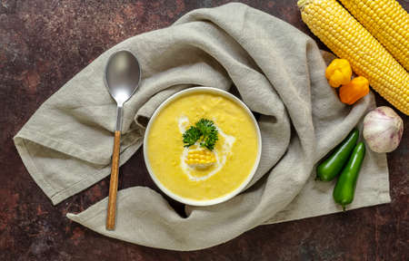Autumn spicy corn soup with garlic, chili, and cream. Top view, fresh ingredients. Vegetarian recipe.の写真素材