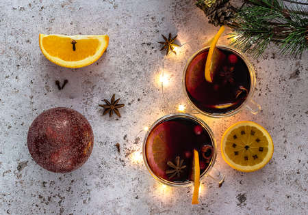 Top view of two glasses of hot mulled wine with oranges and spices with Christmas decorations.の写真素材