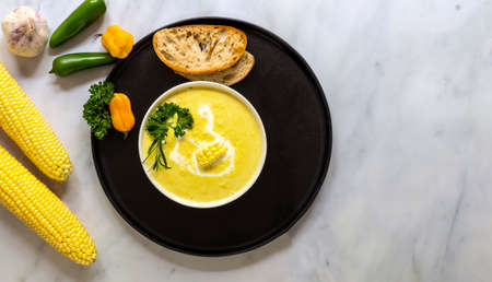 Vegetarian cuisine. Autumn spicy corn soup made of corn, garlic, chili peppers, and cream. Top view, copy space for recipe or text.の写真素材