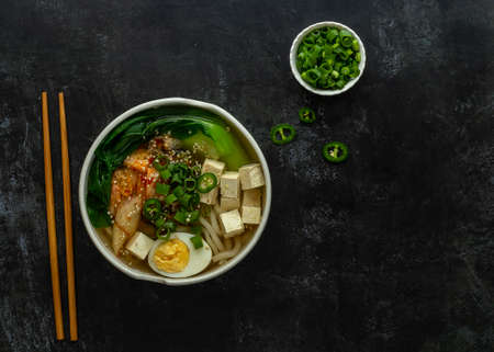 Asian noodle soup Udon with tofu, bok choy cabbage, and kimchi. Vegetarian recipe. Copy space.の写真素材