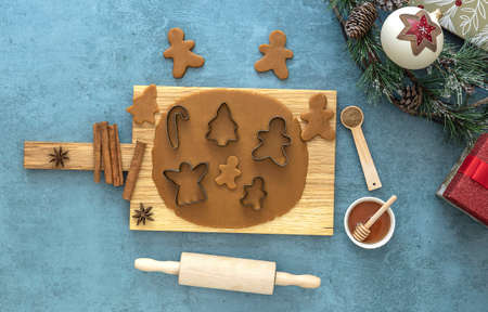 Top view on rolled out dough for Christmas gingerbread cookies with holidays decorations on the wooden tableの写真素材