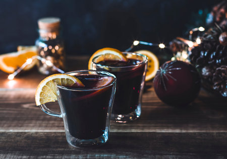 Two glasses of Christmas mulled wine with defocused lights and decorations on the background
