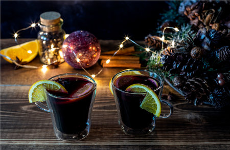 Two glasses of Christmas mulled wine with defocused lights and decorations on the background