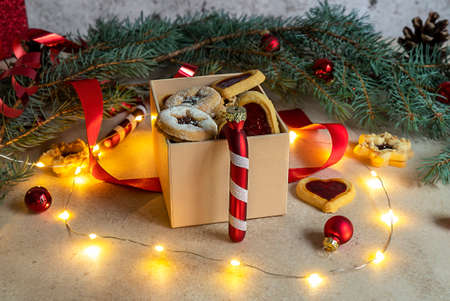Christmas or New Year homemade sweet present in the box. Traditional Austrian winter holiday cookies - Linzer biscuits filled with strawberry jam. Festive decoration.の写真素材