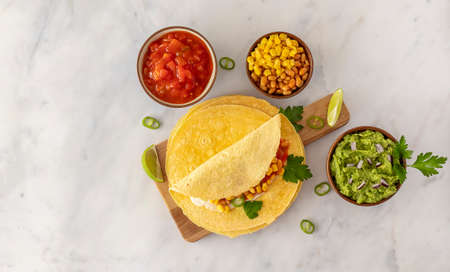 Tortilla wrap or burrito with corn, beans, greens, and homemade guacamole. Vegetarian healthy food, Mexican cuisine. copy space for recipe or text.の写真素材