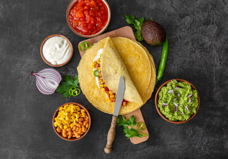 Tortilla wrap or burrito with corn, beans, greens, and homemade guacamole. Vegetarian healthy food,...