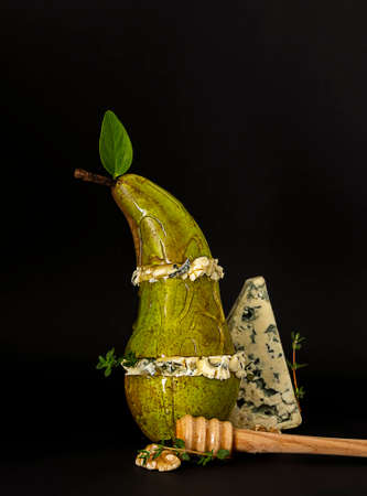 Pear and blue cheese with honey and nuts. Concept gourmet snack. vertical orientation, black backgroundの写真素材
