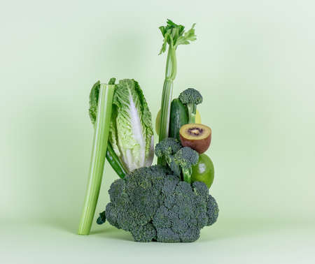 Fresh green vegetables and fruits on a green background. Balancing composition. alkaline diet concept.の写真素材