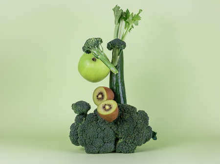 Fresh green vegetables and fruits on a green background. Balanced composition. alkaline diet concept.の写真素材