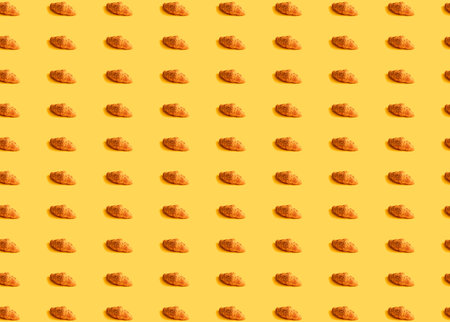 Seamless food pattern with nut butter croissants, yellow background, top view.