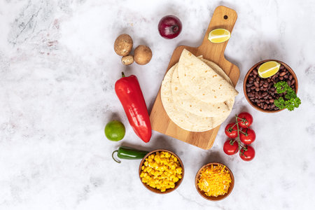 Preparing to cook vegetarian tacos with mushrooms, beans, peppers, corn, and cheese. Traditional mexican food, top view, copy space.の写真素材