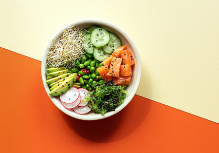 Asian trendy food, sushi poke bowl with edamame beans, cucumber, salmon, avocado, black and white...