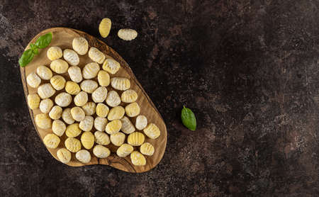 Top view of homemade italian gnocchi made from potatoes, wheat flour dough, eggs. Raw food, prepare to cook. flat lay, copy space for recipe or text.の写真素材
