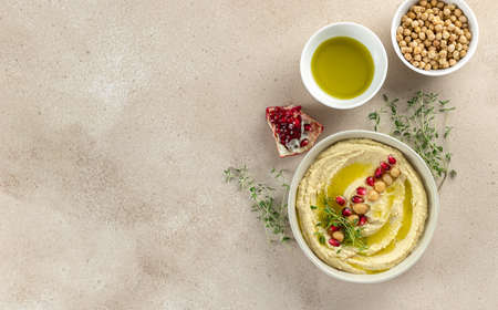Lebanese Hummus, mashed chickpeas with pomegranate, lime, spices, olive oil, and herbs. homemade recipe, healthy snack. Top view, copy space.の写真素材