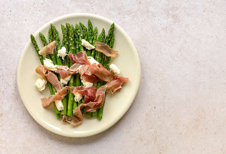 Green asparagus with mozzarella cheese and prosciutto ham. Seasonal delicious food. keto dietary lunch or dinner.の写真素材