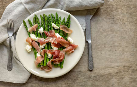 Green asparagus with mozzarella cheese and prosciutto ham. Seasonal delicious food. keto dietary lunch or dinner.の写真素材