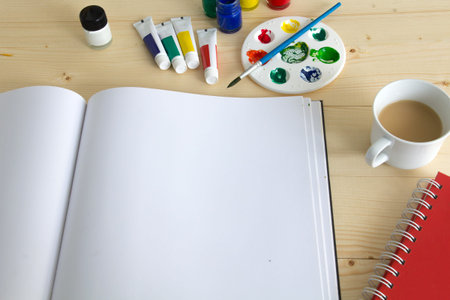 painting equipment and paper on wood table with a cup of teaの写真素材