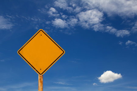blank yellow traffic sign with blue sky