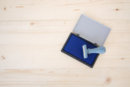 Rubber stamp with blue color stamp pad on wood backgroundの写真素材
