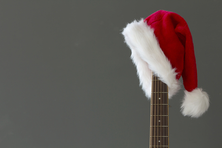 Red Christmas hat on guitar with grey background, Merry Christmasの写真素材