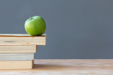a green apple on stack of the old booksの写真素材