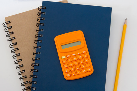 blue and brown color diary books , calculator and pencil on white backgroundの写真素材