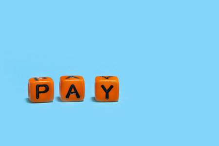 word PAY on orange message cube