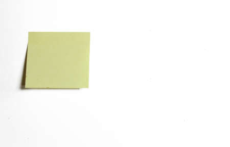 blank yellow note paper posted on white backgroundの写真素材