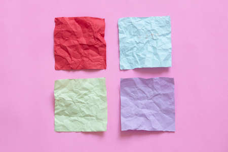 four crumpled note paper on pink backgroundの写真素材