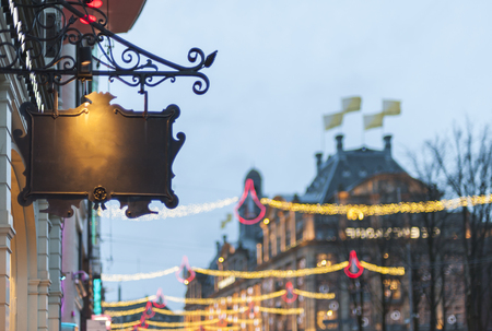 Empty black ornamental sign with lot of out of focus light bulbs with nice bookeh in evening city.の写真素材